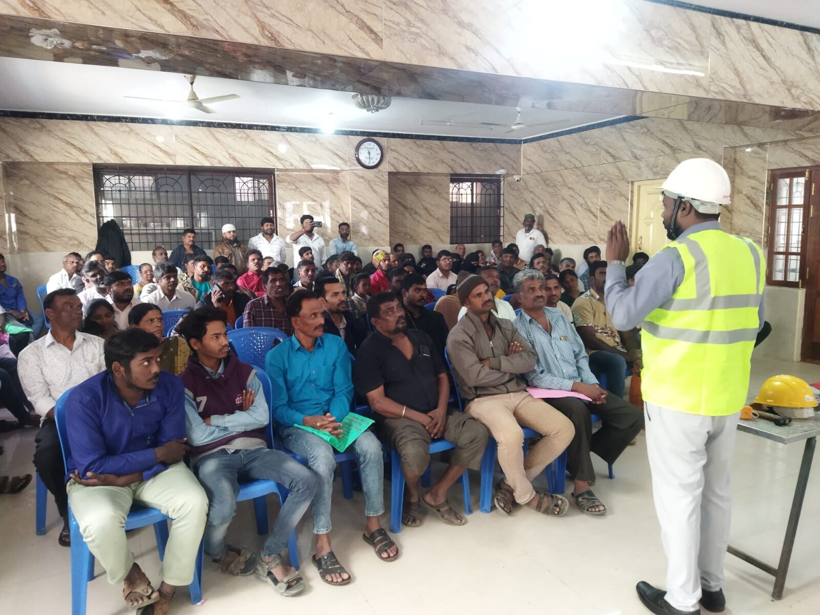 Trainer leading a safety pledge with a full room of construction workers