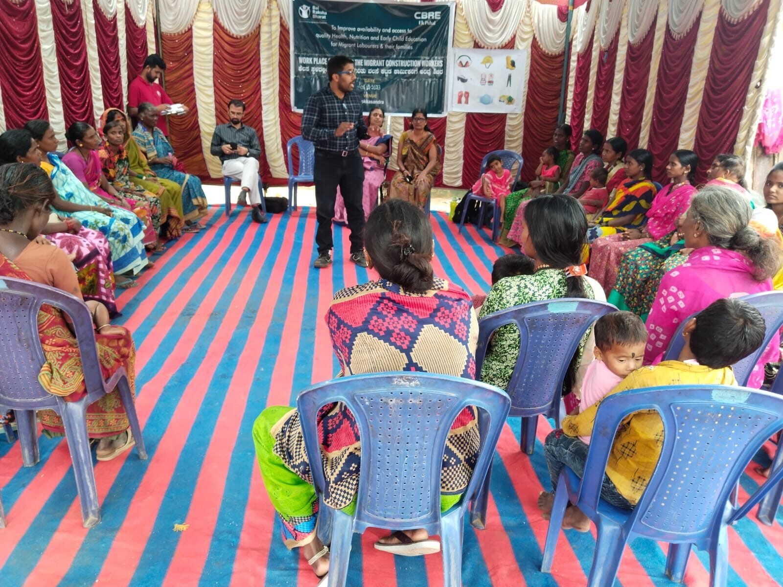 Facilitator speaking to women seated in a circle as part of a health and safety programme